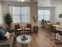 Cozy living room transitioning into a dining area with stylish chairs and modern furnishings at 9756 Ash Ln, Thornton, CO 80229