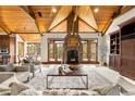 Bright living room showcasing a stone fireplace, wood ceilings, and access to outdoor views at 7115 Parkwood Ln, Castle Pines, CO 80108