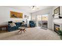 Bright living room featuring a fireplace, ceiling fan, and a sliding glass door to a private balcony at 5534 Lewis St # 202, Arvada, CO 80002