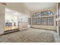 Open-concept living room with large windows, adjoined to a modern kitchen and breakfast bar at 70 Long Bow Cir, Monument, CO 80132