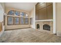 Bright living room featuring high ceilings, arched windows, and a classic brick fireplace at 70 Long Bow Cir, Monument, CO 80132