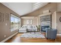 Bright living room featuring a vaulted ceiling, large window, fireplace, and comfortable seating area at 6595 Meade Ct, Arvada, CO 80003
