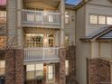 Multi-story condo building featuring private balconies with white railings and brick and siding accents at 5726 N Genoa Way # 204, Aurora, CO 80019