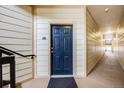 Hallway of unit with dark blue door and beige walls at 5726 N Genoa Way # 204, Aurora, CO 80019