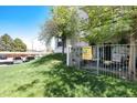 Exterior of building with well-maintained lawn, mature trees, parking, and a ground floor entrance at 2325 S Linden Ct # 101, Denver, CO 80222