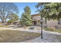 Inviting townhouse exterior with mature trees, landscaped front yard and pedestrian walkway at 3310 S Oneida Way, Denver, CO 80224