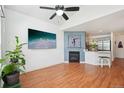 Bright living room with sleek ceiling fan, fireplace, and hardwood floors open to the kitchen at 2408 Concord Cir, Lafayette, CO 80026