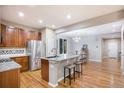 Bright kitchen featuring an island, granite countertops, stainless steel appliances, and access to the dining area at 10247 Telluride Way, Commerce City, CO 80022