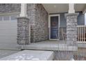 A welcoming front porch featuring stone columns and a wreath on the front door at 1048 Larkspur Dr, Erie, CO 80516