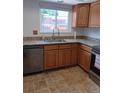 Updated kitchen featuring wood cabinets, granite countertops, and stainless steel dishwasher at 12640 W Virginia Ave, Lakewood, CO 80228