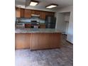 Open kitchen design with center island, stylish countertops, wood cabinets, and stainless appliances at 12640 W Virginia Ave, Lakewood, CO 80228