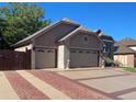 View of the home's exterior showing the two-car garage and manicured landscape at 6833 S Miller St, Littleton, CO 80127