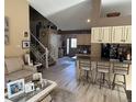 Open-concept living space with hardwood floors, kitchen island and staircase at 6833 S Miller St, Littleton, CO 80127