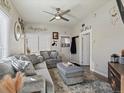 Cozy living room with plush gray sofa, ceiling fan, and plenty of natural light at 402 Harrison Ave, Fort Lupton, CO 80621