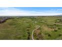 Scenic aerial view of winding trails through a lush green valley and rolling hills with scattered homes at 17223 W 84Th Dr, Arvada, CO 80007
