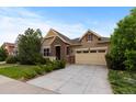 Charming two-story home featuring a well-manicured lawn, brick accents, and an attached two-car garage at 17223 W 84Th Dr, Arvada, CO 80007