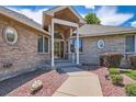 Charming brick home with covered entry and manicured landscaping offers great curb appeal at 7769 W 70Th Dr, Arvada, CO 80004