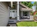Inviting front porch with seating, complemented by a stylish front door and manicured landscaping at 12 Long Spur, Littleton, CO 80127