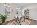 Bright home office with hardwood floors, modern desk, stylish shelving, and natural light streaming through large windows at 1640 Winona Ct, Denver, CO 80204