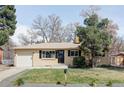 Charming, ranch style home featuring a brick facade, attached garage, and a well-maintained front yard and landscaping at 6580 Independence Way, Arvada, CO 80004