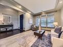 Bright living room featuring tray ceilings, stylish furnishings, a patterned rug, and plenty of natural light at 1648 Exquisite St, Castle Rock, CO 80109