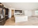 Open-concept kitchen with stainless steel appliances, a large island, and modern finishes at 615 Twilight St, Erie, CO 80516