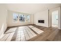 Bright living room with hardwood floors, large windows, and a modern fireplace at 615 Twilight St, Erie, CO 80516
