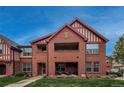 Condo building with brick facade, covered patio, and well-maintained lawn, showcasing its inviting curb appeal at 1379 Charles # 4, Longmont, CO 80503