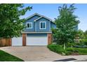 Inviting two-story home with blue siding, a two-car garage, and a well-maintained front yard at 19113 W 60Th Ln, Golden, CO 80403