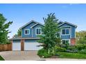 Lovely two-story home with a spacious two-car garage, blue siding, and beautifully landscaped front yard at 19113 W 60Th Ln, Golden, CO 80403