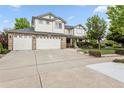 Charming two-story home boasts a three-car garage, green lawn, and beautiful curb appeal at 17391 E Weaver Ave, Aurora, CO 80016