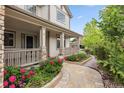 Inviting front porch with stone columns, lush landscaping, and a stone walkway at 17391 E Weaver Ave, Aurora, CO 80016
