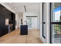 Modern kitchen with dark cabinetry, a kitchen island with a sink, and stainless steel appliances at 1601 Park Ave # 506, Denver, CO 80218