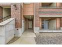 Close-up of a condo building entrance featuring brick accents and secure entry for a cozy and inviting feel at 4100 Albion St # 303, Denver, CO 80216