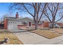 Brick ranch home with a paved driveway and landscaping at 3246 S Stuart St, Denver, CO 80236