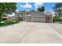 Spacious driveway leads to a charming two-story home with well-manicured lawn and attractive brick accents at 4541 Christensen Cir, Littleton, CO 80123