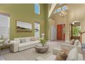 Bright living room with soaring ceilings, chandelier, and neutral décor; perfect for entertaining at 6533 S Ouray St, Aurora, CO 80016