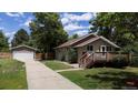A home with a long driveway leading to a detached garage, showcasing the property's curb appeal at 9075 W 66Th Ave, Arvada, CO 80004