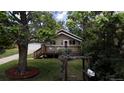 A quaint home nestled among mature trees, featuring a cozy front porch and lush landscaping at 9075 W 66Th Ave, Arvada, CO 80004