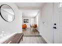Bright entryway with wood flooring, decorative mirror, and views into the dining and living areas at 3249 W Alaska Pl, Denver, CO 80219