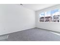 Bright bedroom with neutral carpet, a large window, and ample natural light at 9122 Telluride Ct, Commerce City, CO 80022