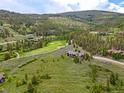 Expansive property featuring a luxurious home with well-maintained grounds next to a lush green golf course at 174 Sage Dr, Breckenridge, CO 80424