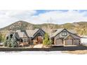 Beautiful exterior showcasing a well-maintained lawn, a stone facade, and an attached three-car garage at 174 Sage Dr, Breckenridge, CO 80424