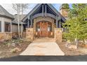 Inviting front entrance featuring a stone pathway, columns, a wooden door, and rocking chairs at 174 Sage Dr, Breckenridge, CO 80424
