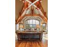 Bright living room with vaulted ceilings, exposed beams, and a large window overlooking snowy mountains at 174 Sage Dr, Breckenridge, CO 80424
