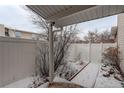 Enclosed back patio with a white fence and a snow-covered ground, perfect for outdoor enjoyment at 2466 S Vaughn Way # A, Aurora, CO 80014