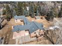 Aerial view of the two-story home featuring a driveway and lots of tall trees at 3720 E Quincy Ave, Cherry Hills Village, CO 80113