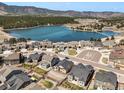 Stunning aerial view of homes overlooking a serene lake surrounded by lush greenery and mountain views at 17855 Lake Side Dr, Monument, CO 80132