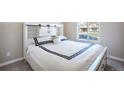 Bright bedroom featuring a comfortable bed with a decorative headboard and view from a window at 17855 Lake Side Dr, Monument, CO 80132