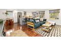 Open-concept living room and kitchen featuring hardwood floors, modern furnishings, and an island at 720 Independence Dr, Longmont, CO 80504